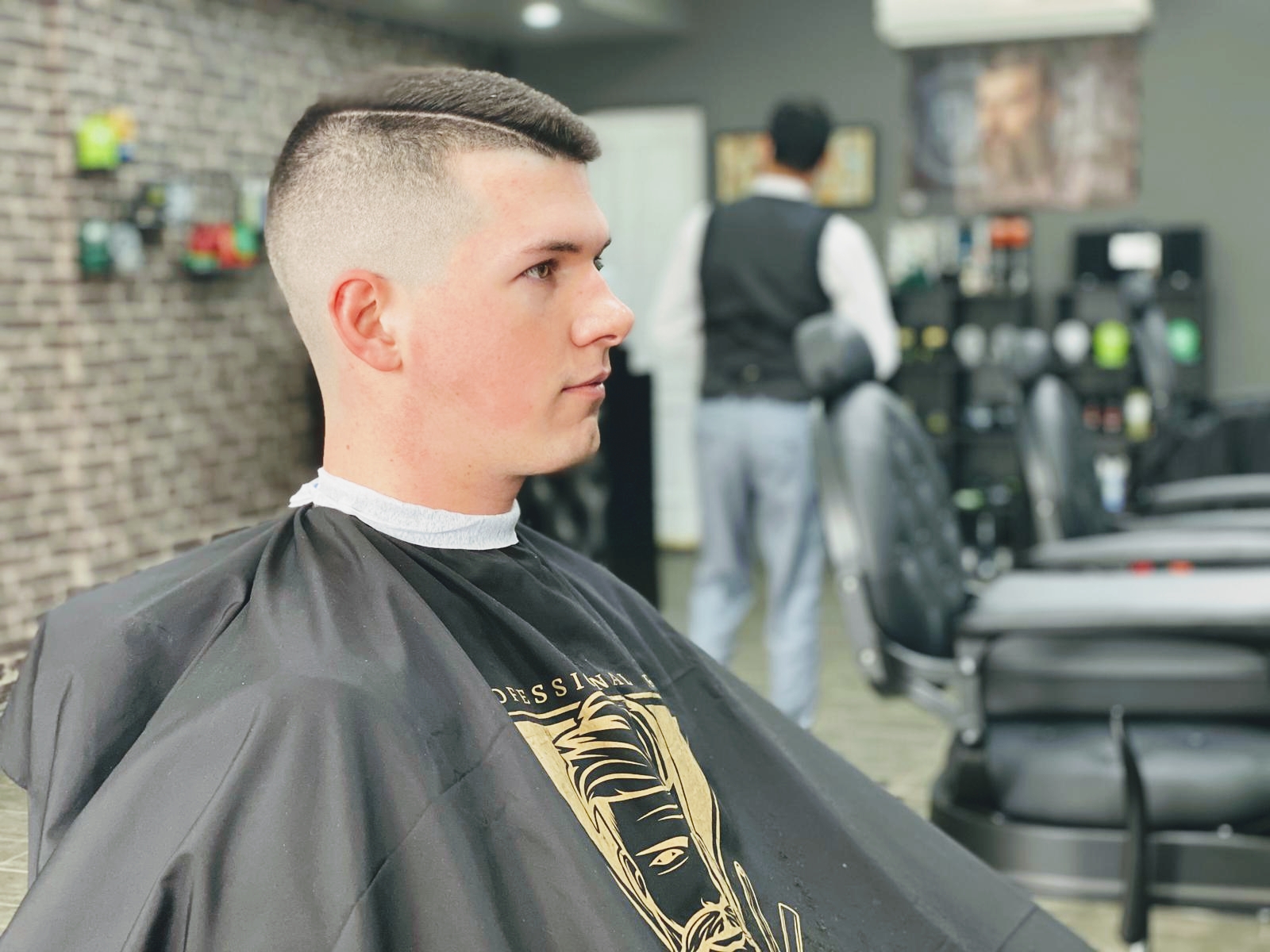 Young man in the chair showing a high skin fade, side profile